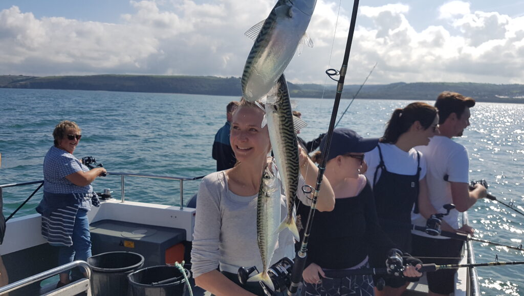 Family and friends fishing for mackerel on an epic fishing trip New Quay Wales